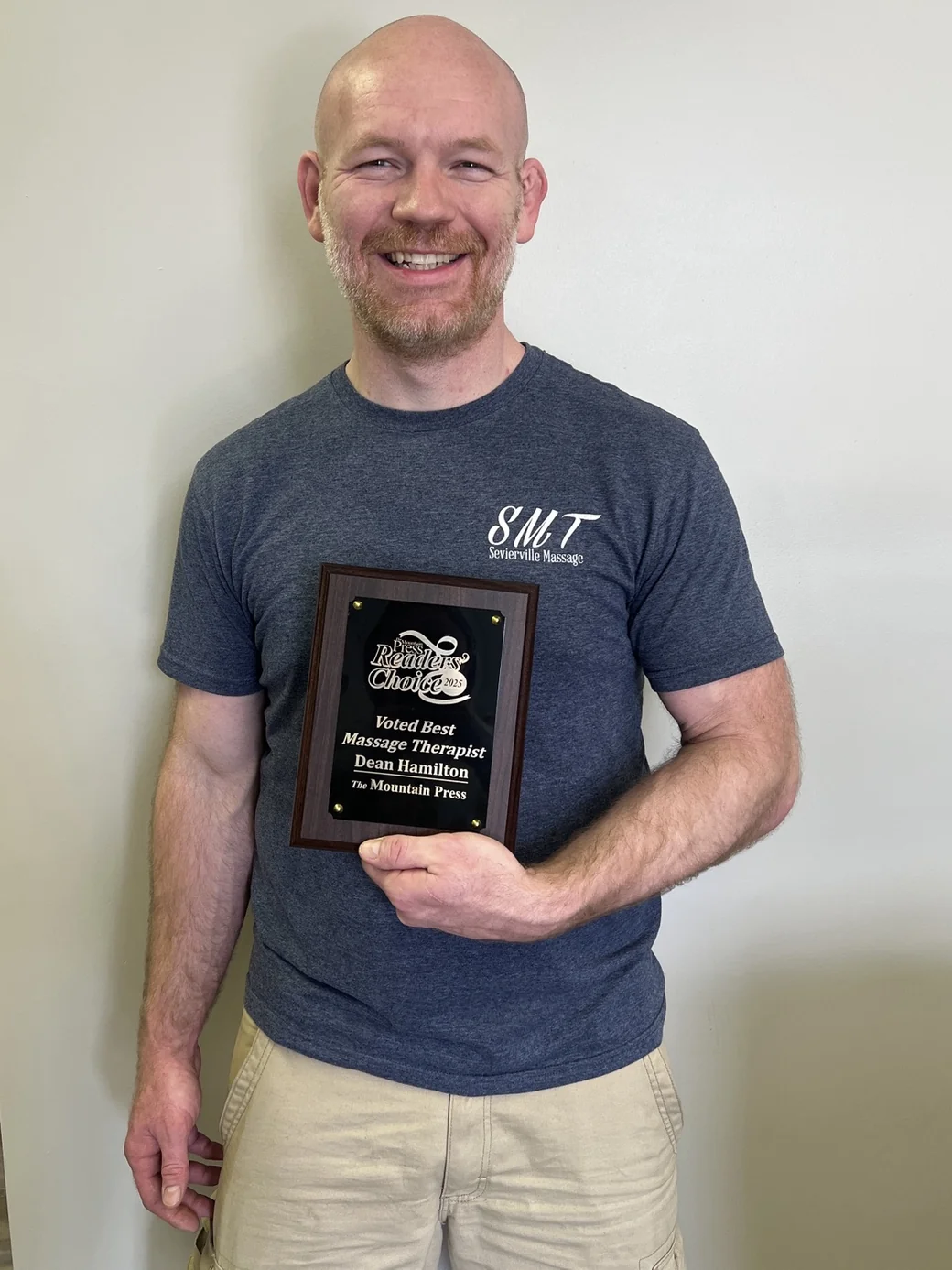 Dean Hamilton holding a Readers' Choice Best Massage Therapist award